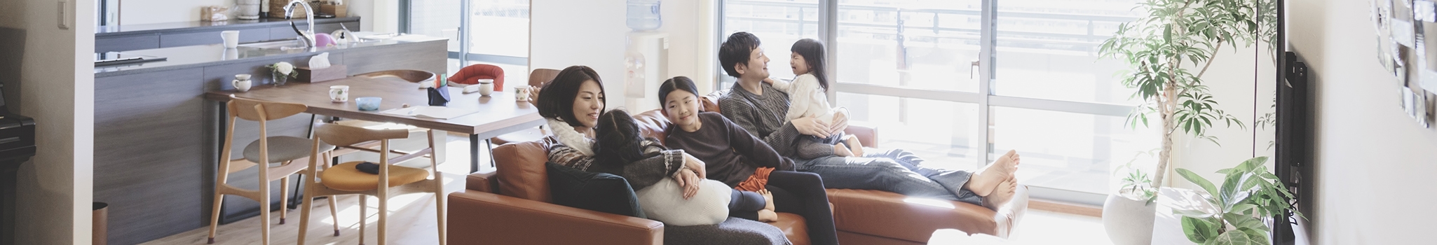Asian family sitting on sofa in the living room.